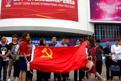 Visitors to the 21st China Beijing International High-tech Expo pose for photos with a Chinese flag in Beijing, China, Thursday, May 17, 2018. The Trump administration has threatened to impose tariffs on up to $150 billion in Chinese imports to punish Beijing over trade practices requiring American companies to hand over technology in exchange for access to the Chinese market. China has counterpunched by targeting $50 billion in U.S. products.