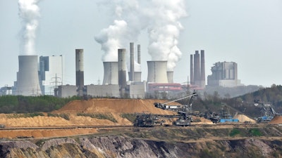 In this April 3, 2014 file photo giant machines dig for brown coal at the open-cast mining Garzweiler in front of a power plant near the city of Grevenbroich in western Germany. Allianz says it will stop insuring coal-fired power plants and coal mines as part of its contribution to combating climate change.