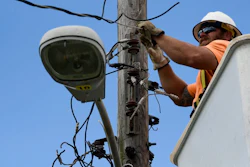 In this May 16, 2018 photo, a worker from the Cobra Energy Company, contracted by the Army Corps of Engineers, installs power lines in the Barrio Martorel area of Yabucoa, a town where many continue without power in Puerto Rico. A group of Corps officials plans to remain in Puerto Rico for several weeks to demobilize contractors and hand logistic operations back to FEMA and PREPA.