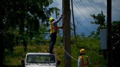 Workers of the electric repair brigade remove old cables from a post in San German, Puerto Rico, Wednesday, May 30, 2018. After an eight-month, $3.8 billion federal effort to try to end the longest blackout in United States history, officials say Puerto Rico’s public electrical authority, the nation’s largest, is almost certain to collapse again when the next hurricane hits this island of 3.3 million people.