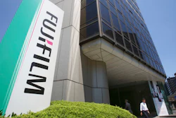A man walks in front of Nishiazabu headquarters of Fujifilm Holdings Corporation in Tokyo, Monday, May 14, 2018. Copier company Xerox Corp. said Sunday it was ending an agreement to combine with Japan's Fujifilm Holdings and is entering a settlement deal with investors Carl Icahn and Darwin Deason.