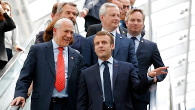 French President Emmanuel Macron, right, and Organisation for Economic Co-operation and Development (OECD) Secretary-General Angel Gurria arrive at the OECD ministerial council meeting on 'Refounding Multilateralism', in Paris, France, Wednesday, May 30, 2018. Macron warned against trade wars in an impassioned speech about international cooperation Wednesday, two days before the Trump administration decides whether to hit Europe with punishing new tariffs.
