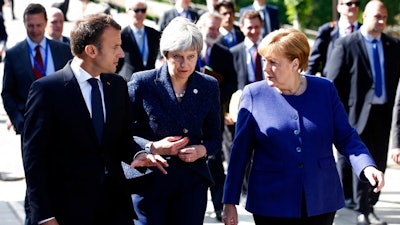 German Chancellor Angela Merkel, right, speaks with French President Emmanuel Macron, left, and British Prime Minister Theresa May after meeting at a hotel on the sidelines of an EU-Western Balkans summit in Sofia, Bulgaria, Thursday, May 17, 2018.