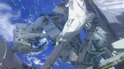 In this frame from NASA TV, NASA astronaut Ricky Arnold, left, and NASA astronaut Drew Feustel work on shuffling around a couple of space station pumps at the International Space Station on Wednesday, May 16, 2018.