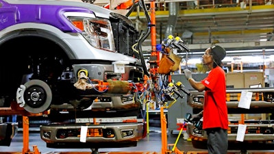 In this March 19, 2018, file photo, a line technician positions a truck front bumper for assembly at the Nissan Canton Assembly Plant, in Canton, Miss. On Wednesday, April 16, the Federal Reserve reports on U.S. industrial production for April.