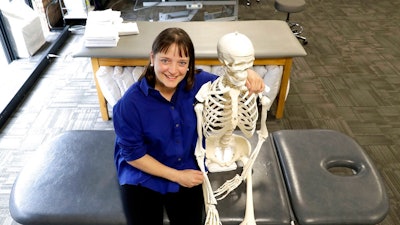 n this Saturday, May 12, 2018, photo, April Oury, owner of Body Gears physical therapy center poses for a portrait with her instructional skeleton in Chicago. Oury started her physical therapy practice 14 years ago wanting to give all aspects of her business the same focus and attention to detail she gave patients, even when it came to choosing paint colors or an internet provider. She wouldn’t do it that way again. “There was not enough time in the day or the workweek to put that kind of effort into every single thing,” says Oury.