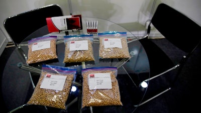 In this file photo, packets of raw soybeans are placed on a table at a U.S. soybean company's booth at the international soybean exhibition in Shanghai, China.