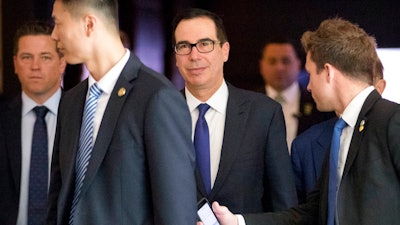 U.S. Treasury Secretary Steven Mnuchin, center, leaves his hotel in Beijing, Friday, May 4, 2018. A high-powered U.S. delegation met for a second day of talks with Chinese officials on defusing tensions that are propelling the world's largest two economies toward a trade war.