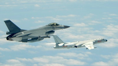 This file photo shows a Taiwanese Air Force fighter aircraft, left, near a Chinese People's Liberation Army Air Force H6-K bomber that reportedly flew over the Luzon Strait south of Taiwan during an exercise.