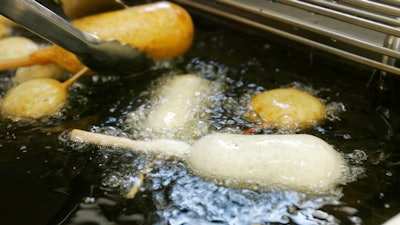In this Aug. 8, 2007 file photo, a Milky-Way candy bar is deep-fried in oil free of trans fats at a food booth at the Indiana State Fair in Indianapolis. Indiana was the first state to require the switch at its state fair. On Monday, May 14, 2018, the head of the World Health Organization called on all nations to eliminate artificial trans fats from foods in the next five years.