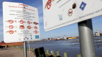 In this March 1, 2018 photo, signs warn people not to fish or crab at River Terrace Park in Channelview, Texas, one of four county parks adjacent to hotspots in the San Jacinto River Waste Pits.