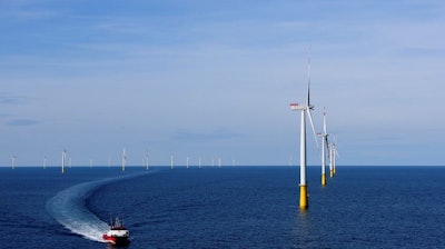 Offshore wind turbines tower over a boat, 90 kilometers from the Danish town of Esbjerg.