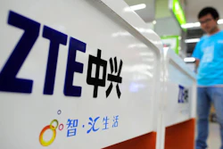 In this Oct. 8, 2012, file photo, a salesperson stands at counters selling mobile phones produced by ZTE Corp. at an appliance store in Wuhan in central China's Hubei province. The tech company, ZTE, a Chinese tech giant brought to its knees and delayed shipments of imported U.S. cars, apples, lumber and other agricultural products are the early casualties as China and the U.S. exchange salvos in a trade dispute.