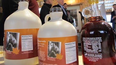 Containers of maple syrup, with nutrition facts on their labels are lined up on a table at Morse Farm Sugarworks in East Montpelier, Vt., Tuesday, May, 1, 2018. Maple syrup and honey producers aren't too sweet on a plan to label their natural products as containing added sugars. The FDA plans to require updated nutrition labels for products that would say that pure maple syrup and honey contain added sugars.