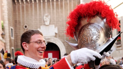 In this May 6, 2007 file photo, an unidentified Swiss Guard puts his helmet on the head of his girlfriend during a ceremony in the 'Honour Courtyard' at the Vatican. The world’s oldest standing army is getting some new headgear. The Swiss Guards plan to replace their metal helmets with plastic PVC ones made with a 3-D printer, giving the pope's army cooler and more comfortable headgear when standing guard for hours at a time.