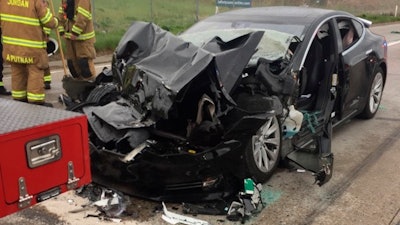 In this Friday, May 11, 2018, file photo released by the South Jordan Police Department shows a traffic collision involving a Tesla Model S sedan with a Fire Department mechanic truck stopped at a red light in South Jordan, Utah. The driver of a Tesla electric car that hit a Utah fire department vehicle over the weekend says the car's semi-autonomous Autopilot mode was engaged at the time of the crash. Police in the Salt Lake City suburb of South Jordan said Monday, May 14, 2018, the driver also said in an interview that she was looking at her phone before the accident. The 28-year-old woman broke her foot when her car hit a fire truck stopped at a red light while going 60 mph (97 kph).