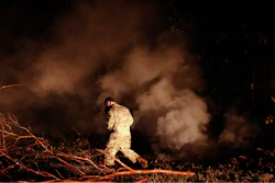 Sgt. 1st Class Carl Satterwaite, of the U.S. National Guard, tests air quality near cracks emitting volcanic gases from a lava flow in the Leilani Estates subdivision near Pahoa, Hawaii Thursday, May 10, 2018. Kilauea has destroyed more than 35 structures since it began releasing lava from vents about 25 miles (40 kilometers) east of the summit crater.