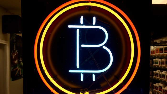 In this Feb. 7, 2018 file photo, a neon sign hanging in the window of Healthy Harvest Indoor Gardening in Hillsboro, Ore., shows that the business accepts bitcoin as payment. A raft of recent cyber-security firms and governments now cite the rising trend of ‘crypto-jacking’ _ in which devices are infected with invisible malicious cryptocurrency mining software that uses the computing power of victims’ devices to mine virtual currency _ as the main cyber security threat to businesses and consumers worldwide.