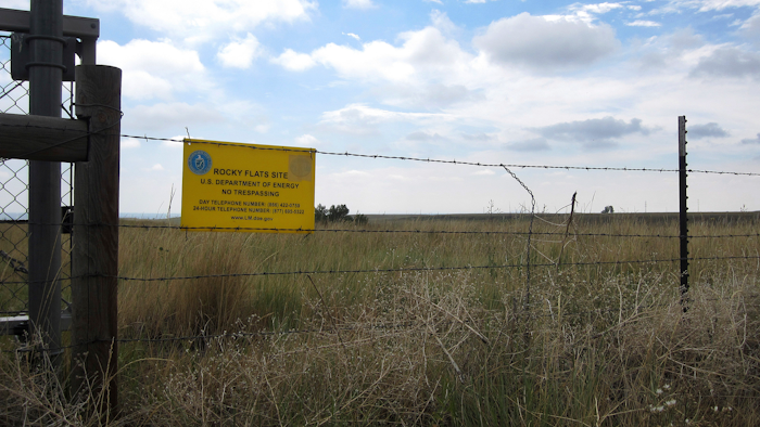 This Aug. 11, 2017 photo shows a 'no trespassing' sign hanging on a fence surrounding part of the former Rocky Flats nuclear weapons plant near Denver. Rocky Flats was once the site of a plant that made plutonium triggers for nuclear weapons. Part of the site was designated a refuge after a $7 billion cleanup, but the area where plutonium was handled remains off-limits. On Sunday, June 3, 2018, the refuge manager harshly criticized a local Colorado health officer who questioned the safety of the site and expressed doubt about whether the U.S. government's assurances about the site could be trusted.