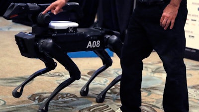 In this Thursday, May 24, 2018, photo Boston Dynamics founder Marc Raibert shows the SpotMini robot during a robotics summit in Boston. It’s never been clear whether robotics company Boston Dynamics is making killing machines, household helpers, or something else entirely. For nine years, the secretive firm, which got its start with U.S. military funding, has unnerved people around the world with YouTube videos of experimental robots resembling animal predators.