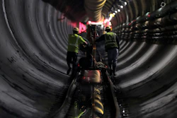 In this Wednesday, May 16, 2018 photo, tunnel workers push equipment up a rail track to a machine boring a 2.5-mile bypass tunnel for the Delaware Aqueduct, in Marlboro, N.Y. Hard-hat workers are toiling deep underground, 55 stories beneath the Hudson River, to eliminate gushing leaks in an aging tunnel that carries half the city's water supply over 85 miles from Catskill Mountain reservoirs.