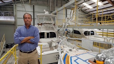 Peter Truslow, Chief Executive Officer for Bertram, a boat building company, poses near three of his custom made boats Friday, June 22, 2018, in Tampa, Fla.