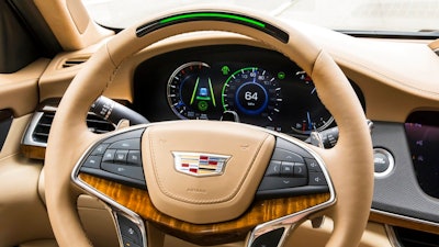 In this undated photo provided by General Motors a steering wheel light bar and cluster icons indicates an active status of Super Cruise in a Cadillac with the green light bar. General Motors is going to expand a hands-free driver-assist system to all Cadillac vehicles starting in 2020, with plans to roll it out to more brands in the future.