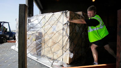 In this July 16, 2010, file photo, Mark Wilson pushes air cargo cleared for shipment to Santiago, Chile, at the American Airline cargo processing warehouse at Dallas-Fort Worth International Airport in Grapevine, Texas. U.S. authorities are requiring airlines to give them more notice about certain types of cargo that officials believe may pose a security risk. The new measure took effect Tuesday, June 12, 2018.