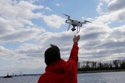 In this April 29, 2018, file photo, a drone operator helps to retrieve a drone after photographing over Hart Island in New York. Science advisers to the federal government say safety regulators should do more to speed the integration of commercial drones into the nation's airspace. The National Academies of Science, Engineering and Medicine said in a report Monday that federal safety regulators are often 'overly conservative' and need to balance the overall benefits of drones instead of focusing only on their risk to airplanes and helicopters.