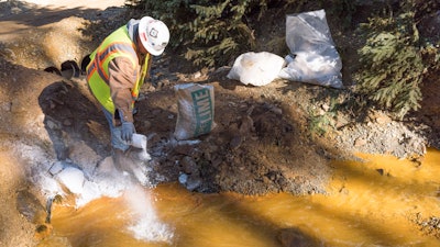 As water exits the Gold King mine, it flows into a system of four treatment ponds. The treatment ponds provide retention time to allow the pH to adjust. Here, lime is added to a settling pond to assist in the pH adjustment of the water prior to discharge to Cement Creek on Aug 14, 2015.