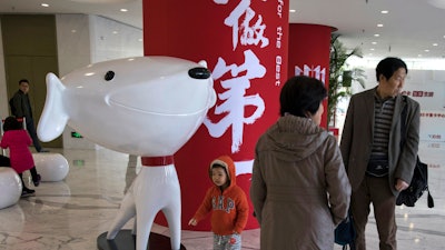 In this photo, a child stands near the mascot for Chinese e-commerce giant JD.com at its headquarters in Beijing, China.