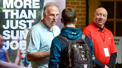 In this March 14, 2018, file photo, Dan Cieslak, left, a Human Resources representative for the Dunham's Distribution Center, and Warren Whitlow, a training manager, speak to students and other visitors during the Experience Indiana job fair event in the student center at Indiana Wesleyan University in Marion, Ind. The U.S. government issues the May jobs report on Friday, June 1.