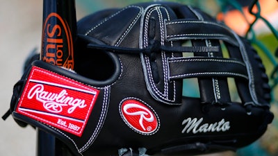 This Feb. 15, 2014 file photo shows a Rawlings glove belonging to Baltimore Orioles coach Jeff Manto at the team's baseball spring training facility in Sarasota, Fla. Newell Brands is selling iconic sporting goods company Rawlings to a private equity fund for about $395 million. The sale, Tuesday, June 5, 2018 is part of a broader plan at Newell Brands Inc. to sell some units and focus on key brands. It recently sold its disposable cups and cutlery business for about $2.2 billion.