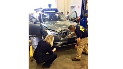 In this March 20, 2018 file photo provided by the National Transportation Safety Board, investigators examine a driverless Uber SUV that fatally struck a woman in Tempe, Ariz. An Arizona police report says the human backup driver the Uber autonomous SUV was streaming a television show on Hulu just before the vehicle struck and killed a pedestrian in March. The Arizona Republic reported that the driver was watching “The Voice,” a television musical talent show. The newspaper received the more than 300-page report from Tempe police on Thursday, June 21.