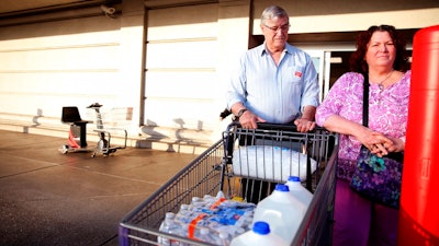 In this Tuesday, May 29, 2018 photo, Mark Schonbrun, 72, and Linda Schonbrun, 66, of West Salem, purchase water following a tap water contamination warning for people in Salem at WinCo Foods in Salem, Ore.