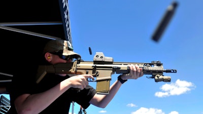 In this June 28, 2014 file photo, a bullet casing flies from the rifle as Derrick Campbell fires downrange at targets during the second annual Freedom Shoot at Pawnee Sportsmen Center near Briggsdale, Colo. The California Supreme Court will decide whether state laws can be challenged in court on the grounds that complying with them is impossible in a lawsuit over a California law that requires new models of semi-automatic handguns to stamp identifying information on bullet casings.