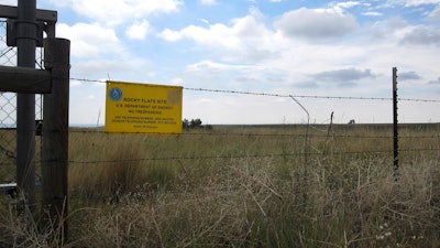 This Aug. 11, 2017 photo shows a 'no trespassing' sign hanging on a fence surrounding part of the former Rocky Flats nuclear weapons plant near Denver. Rocky Flats was once the site of a plant that made plutonium triggers for nuclear weapons. Part of the site was designated a refuge after a $7 billion cleanup, but the area where plutonium was handled remains off-limits. On Sunday, June 3, 2018, the refuge manager harshly criticized a local Colorado health officer who questioned the safety of the site and expressed doubt about whether the U.S. government's assurances about the site could be trusted.