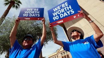 Roger Parrish and Diane Johnson, right, rally outside the Capitol in Phoenix, Wednesday, June 6, 2018. Hundreds of Navajo Generating Station employees, relatives and union and tribal leaders rallied at the state Capitol in Phoenix on Wednesday to request a 90-day pause in steps to close the coal-fueled plant by the end of 2019 as scheduled.