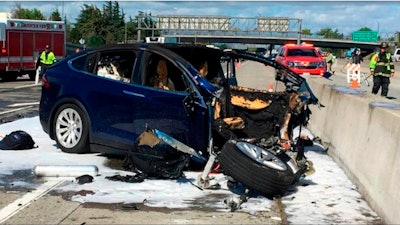 In this March 23, 2018, file photo provided by KTVU, emergency personnel work at the scene where a Tesla electric SUV crashed into a barrier on U.S. Highway 101 in Mountain View, Calif. Federal investigators say the Tesla using the company’s semi-autonomous driving system accelerated just before crashing into a California freeway barrier, killing its driver. The National Transportation Safety Board issued a preliminary report on the crash on Thursday, June 7.