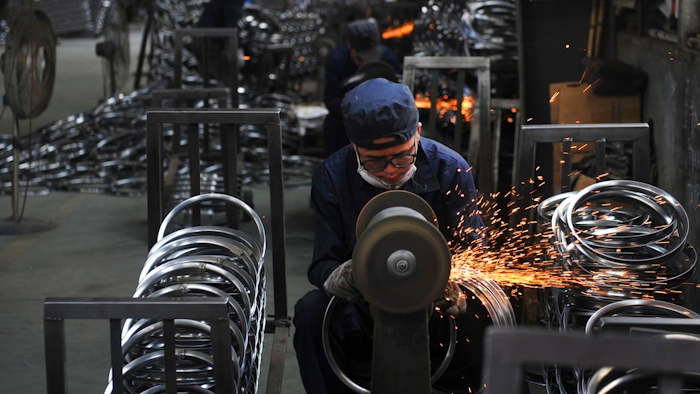 In this June 4, 2018, photo, a worker wields steel wheel rims at a factory in Hangzhou in east China's Zhejiang province. China launched a trade investigation Monday, July 23, 2018 of steel from Europe and South Korea, potentially complicating efforts to recruit them as allies in its tariff dispute with U.S. President Donald Trump.