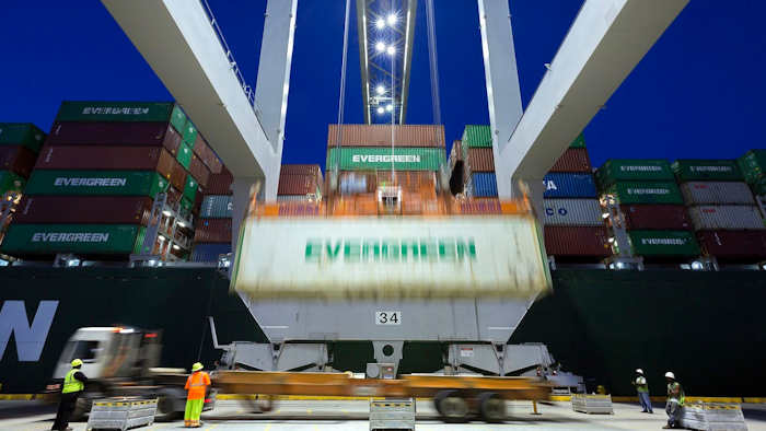 In this June, 19, 2018, file photo, an Evergreen Line refrigerated container is lifted by a ship to shore crane onto the container ship Ever Linking at the Port of Savannah in Savannah, Ga. The U.S. trade deficit dropped in May to the lowest level in 19 months as U.S. exports rose to a record level. But the trade gap between the United States and China increased sharply, underscoring the economic tensions between the world’s two biggest economies.