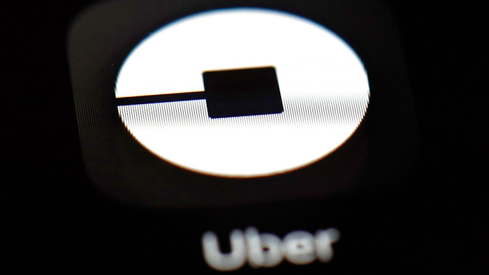 This March 20, 2018, file photo shows the Uber app on an iPad in Baltimore. U.S. employment regulators are investigating allegations that Uber set up a pay scale that discriminated against women working for the ride-hailing service.