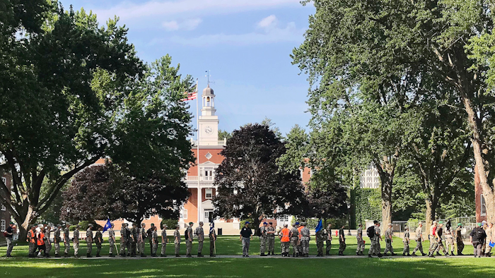 In this Monday, July 16, 2018 photo, students from the Corps of Cadets march in front of Jackman Hall, rear, on the campus of Norwich University in Northfield, Vt. Norwich has become the latest school to offer income share agreements, where colleges receive a percentage of the student's future salary, in place of some student loans.