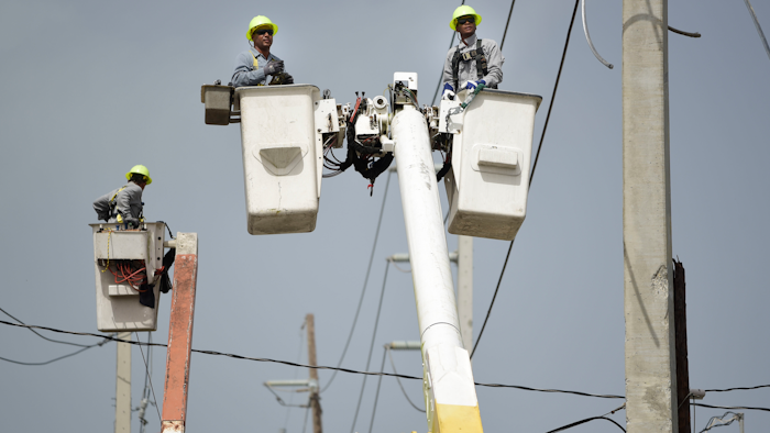 In this Oct. 19, 2017 file photo, a brigade from the Electric Power Authority repairs distribution lines damaged by Hurricane Maria in the Cantera community of San Juan, Puerto Rico. Jose Ortiz will take over Puerto Rico's Electric Power Authority on July 23, 2018, the company's second CEO in two weeks as it struggles with leadership issues, bankruptcy and the restoration of electricity to hundreds who have remained in the dark since Hurricane Maria.