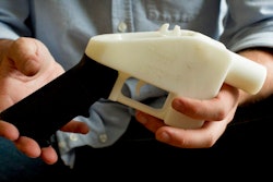 In this May 10, 2013, file photo, Cody Wilson holds what he calls a Liberator pistol that was completely made on a 3-D-printer at his home in Austin, Texas. Eight states filed suit Monday, July 30, 2018, against the Trump administration over its decision to allow a Texas company to publish downloadable blueprints for a 3D-printed gun, contending the hard-to-trace plastic weapons are a boon to terrorists and criminals and threaten public safety.