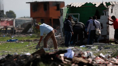 Locals search the area where several fireworks workshops blew up in Tultepec, Mexico, Thursday, July 5, 2018. More than a dozen people were killed and at least 40 injured when a series of explosions ripped through fireworks workshops in a town just north of Mexico City.