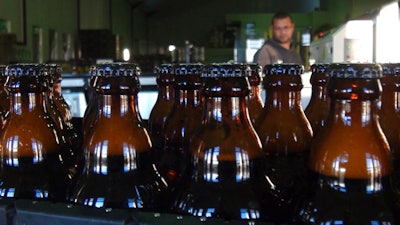 In this June 5, 2018, photo, bottles of freshly bottled beer stand in the Darling Brewery in Darling, South Africa. The South African brewery appears to be the first in Africa to go carbon-neutral as more businesses across the continent adjust to climate change, and as consumers become more careful about the products they buy.