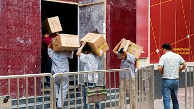 Workers carry boxes of LED lights into a renovation site in Beijing, China, Tuesday, July 3, 2018. Barring a last-minute breakthrough, the Trump administration on Friday will start imposing tariffs on $34 billion in Chinese imports. And China will promptly strike back with tariffs on an equal amount of U.S. exports.
