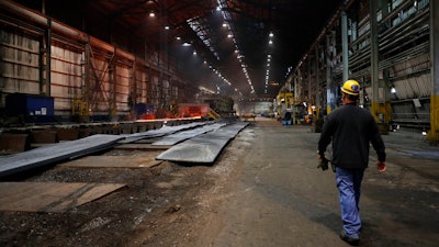 In this June 28, 2018, file photo, a worker walks inside the hot-strip mill at the U.S. Steel Granite City Works facility in Granite City, Ill. On Tuesday, July 17, the Federal Reserve reports on U.S. industrial production for June.