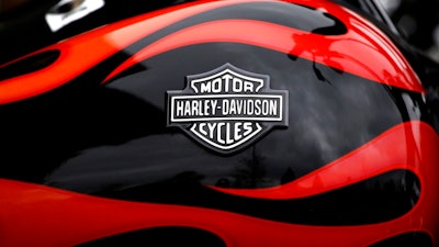 This April 27, 2017, file photo shows the Harley-Davidson name on the gas tank of a bike in Glenview, Ill. The iconic American motorcycle company, facing dwindling sales in its home market, said Monday, July 30, 2018, that it would be rolling out some new products, and stores, to broaden its audience and hopefully, invigorate sales.